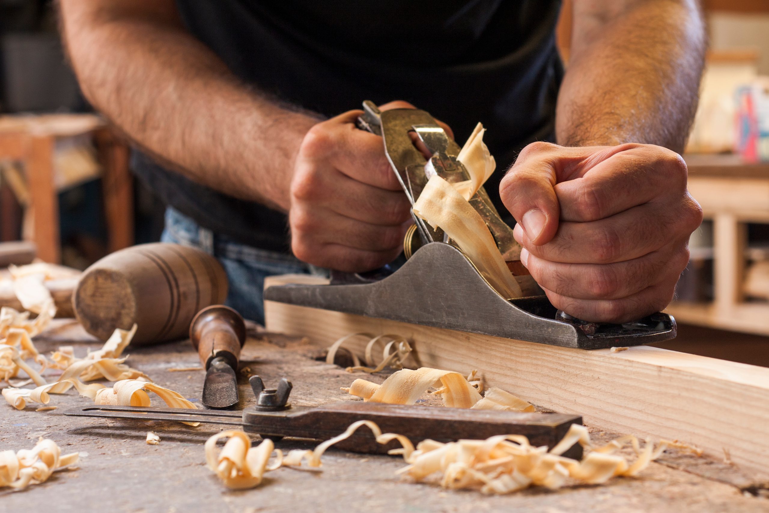carpenter working with plane on wooden background carpenter working with plane on wooden background